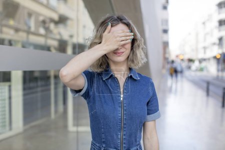 Photo for Pretty woman covering eyes with one hand feeling scared or anxious, wondering or blindly waiting for a surprise - Royalty Free Image