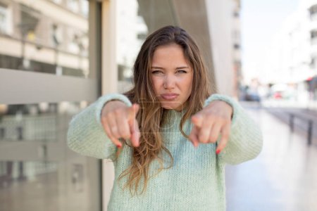 Photo for Pretty hispanic woman pointing forward at camera with both fingers and angry expression, telling you to do your duty - Royalty Free Image