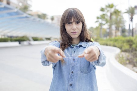 Photo for Pretty young woman pointing forward at camera with both fingers and angry expression, telling you to do your duty - Royalty Free Image