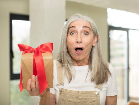 Foto de Mujer mayor sosteniendo una caja de regalo - Imagen libre de derechos
