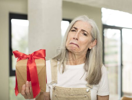 Téléchargez les photos : Femme âgée tenant une boîte cadeau - en image libre de droit