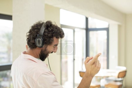 Foto de Joven loco escuchando música con auriculares - Imagen libre de derechos
