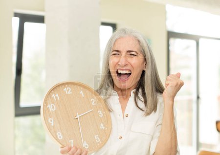 Téléchargez les photos : Senior femme avec une horloge - en image libre de droit