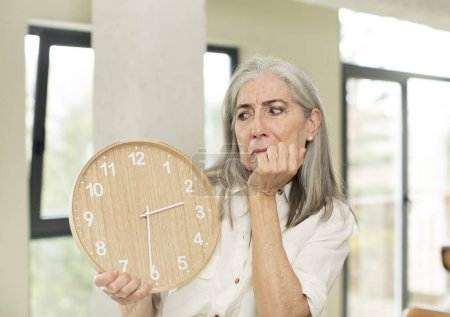 Téléchargez les photos : Senior femme avec une horloge - en image libre de droit