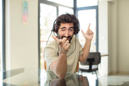 Foto de Hombre hispano barbudo con auriculares y escuchar música - Imagen libre de derechos