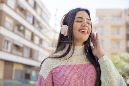 Téléchargez les photos : Jeune jolie femme avec écouteurs écouter de la musique - en image libre de droit