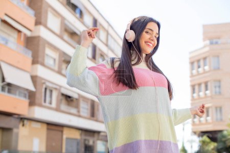 Téléchargez les photos : Jeune jolie femme avec écouteurs écouter de la musique - en image libre de droit