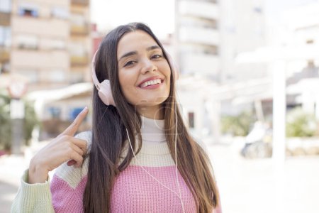 Foto de Joven bonita mujer con auriculares escuchando música - Imagen libre de derechos