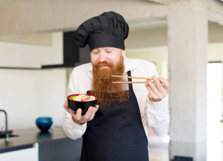 Photo for Young bearded man with an asian noodles bowl - Royalty Free Image