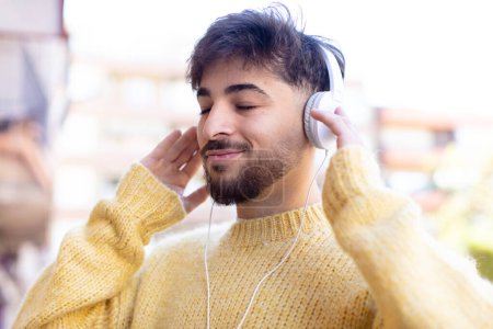 Foto de Hombre árabe joven escuchando música con auriculares - Imagen libre de derechos