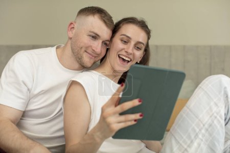 Photo for Young caucasian couple with a touch screen pad - Royalty Free Image
