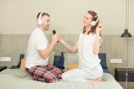 Foto de Joven pareja caucásica escuchando música con auriculares - Imagen libre de derechos