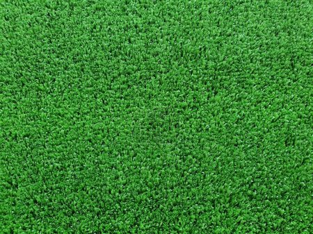 Photo for Artificial turf is a surface made of synthetic fibers. to replace natural grass It is tough and flexible, often used for sports fields that are played on real grass. - Royalty Free Image