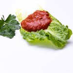 Red tomato paste appetizer placed on lettuce leaf
