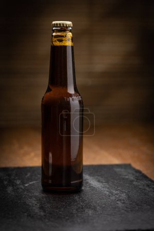 Bottle of beer with a brown glass on wooden background
