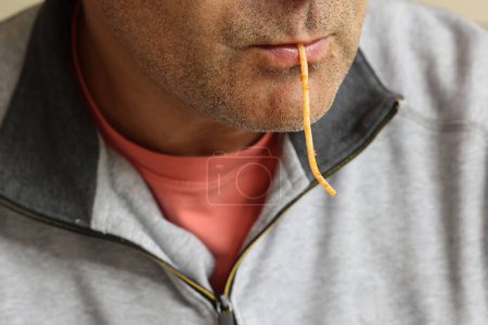 Close - up of man 's mouth sucking spaghetti