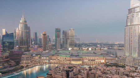Téléchargez les photos : Vue aérienne du quartier du Centre financier international de Dubaï, de jour comme de nuit. Tours de bureaux et hôtels avec gratte-ciel modernes et centre commercial au centre-ville - en image libre de droit