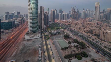 Téléchargez les photos : La baie d'affaires de Dubaï s "étend de nuit aérienne au jour le jour. Vue panoramique sur le toit de certains gratte-ciel et de nouveaux bâtiments en construction avant le lever du soleil - en image libre de droit