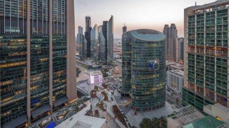 Foto de Dubai centro financiero internacional rascacielos antena día a noche timelapse transición. Torres iluminadas y paseo marítimo en la avenida de la puerta vista panorámica desde arriba - Imagen libre de derechos