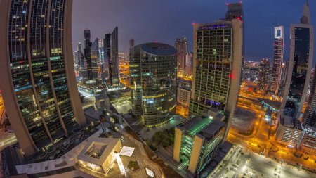 Photo for Panorama of Dubai international financial center skyscrapers aerial night to day transition timelapse. Illuminated towers view from above before sunrise - Royalty Free Image