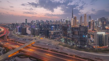 Photo for Skyline with modern architecture of Dubai business bay towers and downtown skyscrapers day to night transition timelapse. Aerial view with canal and construction site after sunset - Royalty Free Image