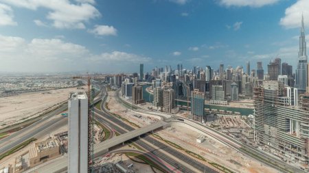 Photo for Panorama showing skyline of Dubai with business bay and downtown district timelapse. Aerial view of many modern skyscrapers with cloudy blue sky. United Arab Emirates. - Royalty Free Image