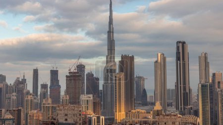 Photo for Panoramic skyline of Dubai downtown district with business bay morning timelapse. Aerial view of many modern skyscrapers with sun reflections during sunrise. United Arab Emirates. - Royalty Free Image