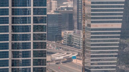 Téléchargez les photos : Vue aérienne rapprochée de la ville des médias et du quartier d'al barsha Heights depuis la marina de Dubaï. Vue entre tours et gratte-ciel avec circulation sur un pont autoroutier d'en haut - en image libre de droit