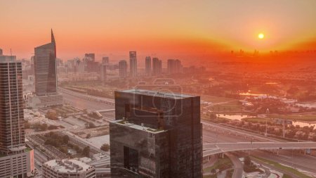 Foto de Salida del sol sobre la ciudad de los medios de comunicación y al barsha alturas distrito timelapse aéreo de Dubai marina. Torres y rascacielos con campo de golf y el tráfico en una carretera desde arriba - Imagen libre de derechos