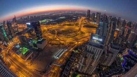 Téléchargez les photos : Marina de Dubaï avec la ville des médias et JLT éclairé gratte-ciel le long de Sheikh Zayed Road nuit aérienne à la transition de jour timelapse panoramique avant le lever du soleil. Immeubles résidentiels et de bureaux d'en haut. - en image libre de droit