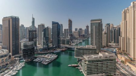 Foto de Panorama que muestra vista aérea a los rascacielos del puerto deportivo de Dubai alrededor del canal con barcos flotantes y jlt con los distritos jbr timelapse. Barcos blancos están estacionados en el club de yates - Imagen libre de derechos