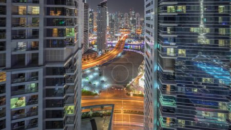 Téléchargez les photos : Panorama montrant la Marina de Dubaï et le quartier de JBR et le célèbre timelapse de nuit aérien Ferris Wheel et les gratte-ciel éclairés et la circulation dans les rues - en image libre de droit