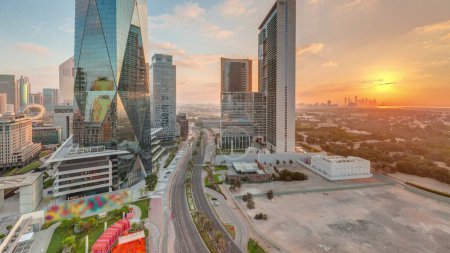 Foto de Salida del sol en el distrito financiero internacional de Dubai timelapse transición. Vista aérea panorámica de las torres de oficinas de negocios por la mañana. Rascacielos con cielo nublado naranja - Imagen libre de derechos