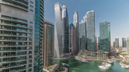 Téléchargez les photos : Panorama montrant les plus hauts gratte-ciels et yachts de la marina de Dubaï dans un timelapse aérien portuaire. Vue sur les immeubles d'appartements, les hôtels et les immeubles de bureaux, développement résidentiel moderne des EAU - en image libre de droit