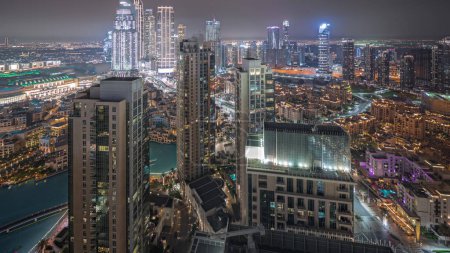 Foto de Panorama mostrando vista aérea de un gran timelapse futurista de la noche de la ciudad. Bahía de negocios y distrito centro con muchos rascacielos y casas tradicionales, Dubai, Emiratos Árabes Unidos skyline. - Imagen libre de derechos