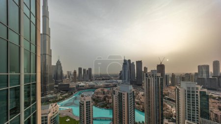 Téléchargez les photos : Dubaï centre-ville au lever du soleil avec fontaines et architecture futuriste moderne timelapse aérien. Vue panoramique sur les gratte-ciel avec la vieille ville et le centre commercial - en image libre de droit