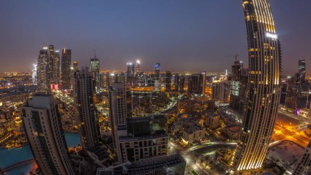 Téléchargez les photos : Panorama aérien d'une grande ville futuriste nuit à jour transition timelapse. Baie d'affaires et quartier du centre-ville avant le lever du soleil avec gratte-ciel et maisons traditionnelles, Dubaï, Émirats arabes unis skyline. - en image libre de droit