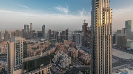 Foto de Panorama que muestra el horizonte panorámico aéreo de una gran ciudad futurista durante el lapso de tiempo del atardecer. Business bay y Downtown district con rascacielos y casas tradicionales, Dubai, Emiratos Árabes Unidos - Imagen libre de derechos