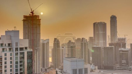 Foto de Aerial sunrise over big futuristic city timelapse. Business bay y Downtown district con rascacielos, Dubai, Emiratos Árabes Unidos skyline. - Imagen libre de derechos