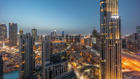 Téléchargez les photos : Vue aérienne panoramique d'une grande ville futuriste nuit à jour transition timelapse. Baie d'affaires et quartier du centre-ville avant le lever du soleil avec gratte-ciel et maisons traditionnelles, Dubaï, Émirats arabes unis skyline. - en image libre de droit