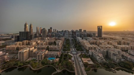 Foto de Panorama de rascacielos en el distrito de Barsha Heights y edificios de poca altura en el timelapse aéreo del distrito de Greens durante todo el día desde el amanecer. Dubai skyline con sombras moviéndose rápido - Imagen libre de derechos
