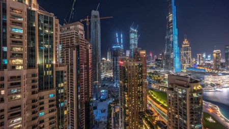 Foto de Dubai Centro de paisaje urbano con rascacielos más altos en construcción timelapse noche aérea. Nuevas torres con ventanas brillantes y carreteras ocupadas con tráfico desde arriba - Imagen libre de derechos