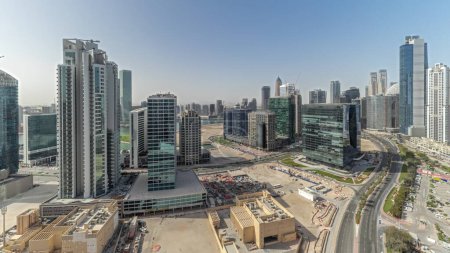 Téléchargez les photos : Panorama montrant Bay Avenue avec des tours modernes développement résidentiel dans Business Bay timelapse aérien, Dubaï, EAU. gratte-ciel avec grand parking et chantier de construction - en image libre de droit