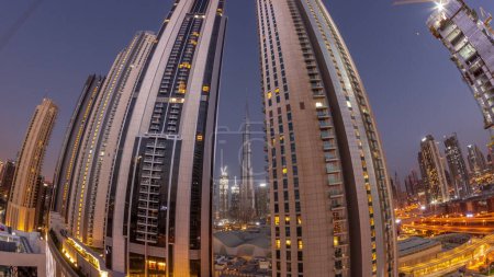 Téléchargez les photos : Panorama des plus hauts gratte-ciel du centre-ville de Dubai situé sur la rue bouleward près du centre commercial aérien nuit au jour passage timelapse. Zone de marche avec jardins sur le toit avant le lever du soleil - en image libre de droit