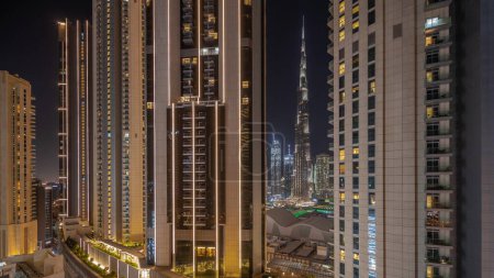 Téléchargez les photos : Panorama montrant les plus hauts gratte-ciel pendant l'heure de la Terre dans le centre-ville de Dubai situé sur la rue bouleward près du centre commercial timelapse nocturne aérienne. Lumières et éclairage allumés après une heure - en image libre de droit