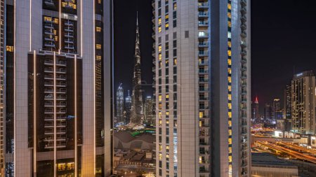 Téléchargez les photos : Panorama montrant les plus hauts gratte-ciel pendant l'heure de la Terre dans le centre-ville de Dubai situé sur la rue bouleward près du centre commercial timelapse nocturne aérienne. Éteindre les lumières pendant une heure - en image libre de droit
