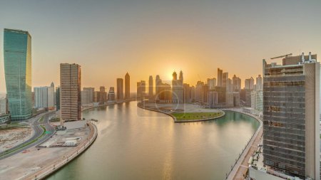 Téléchargez les photos : Coucher de soleil paysage urbain de gratte-ciel à Dubai Business Bay avec canal d'eau aérienne timelapse panoramique. Skyline moderne avec tours et front de mer. Un centre d'affaires international - en image libre de droit