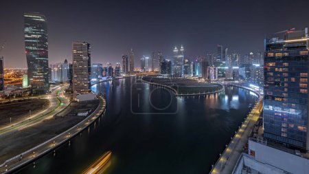 Foto de Panorama que muestra el paisaje urbano de los rascacielos en Dubai Business Bay con el canal de agua de la noche aérea timelapse. skyline moderno con torres iluminadas y paseo marítimo. Un centro de negocios internacionales - Imagen libre de derechos