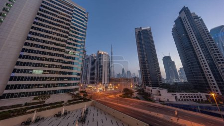 Foto de Vista panorámica aérea hacia el centro de Dubái y dic rascacielos con tráfico ocupado en la intersección en el distrito de la bahía de negocios noche a día timelapse transición. - Imagen libre de derechos