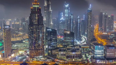 Foto de Vista aérea de las torres más altas del horizonte del centro de Dubái durante toda la noche con las luces apagadas. Distrito financiero y área de negocios en la ciudad urbana inteligente. Rascacielos y edificios de gran altura - Imagen libre de derechos